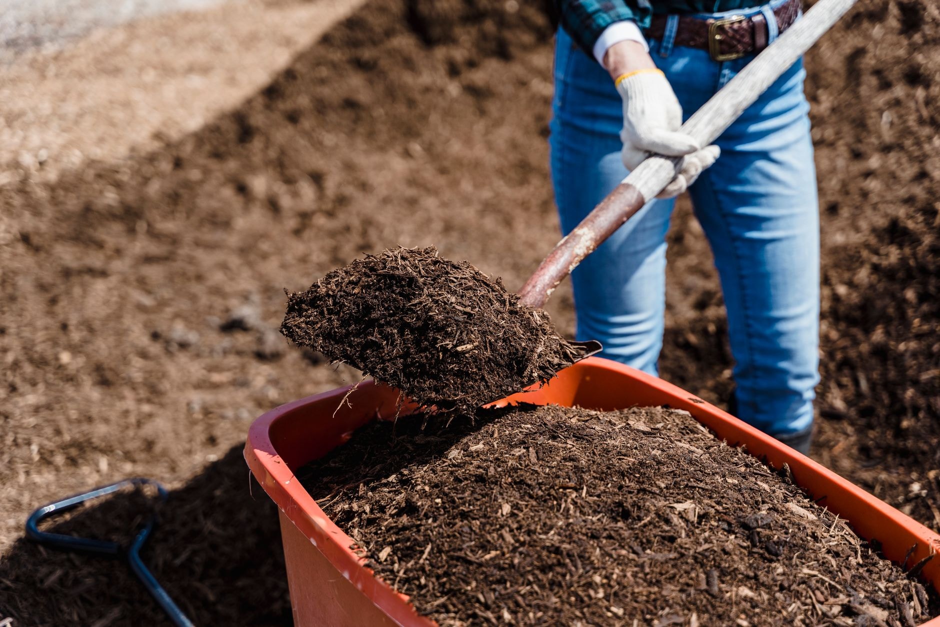 Jardinier retournant un tas de compost à la fourche